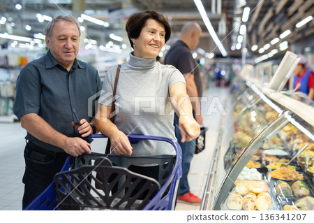 Married couple choose groceries together in supermarket Married couple choose groceries together in supermarket 136341207