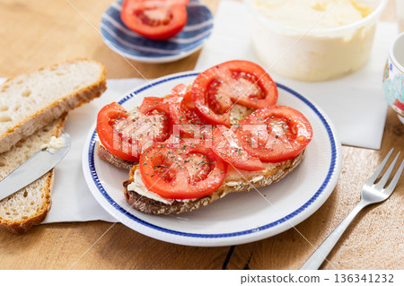 two bruschettas with tomato slices on a plate two bruschettas with tomato slices on a plate 136341232