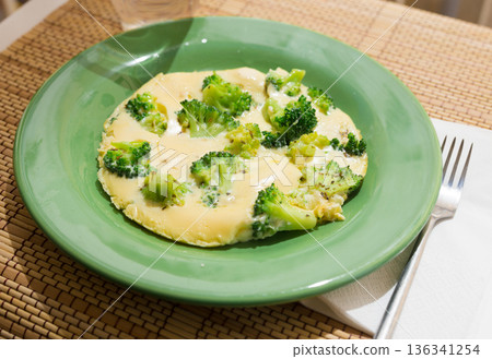 wholesome breakfast. omelet with broccoli on green plate wholesome breakfast. omelet with broccoli on green plate 136341254