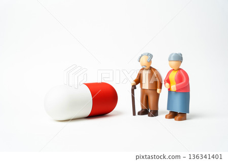 An elderly couple and a medicine capsule. Access to medications and healthcare for seniors and retirees. Affordable treatment supports longevity, care planning and quality aging. 136341401