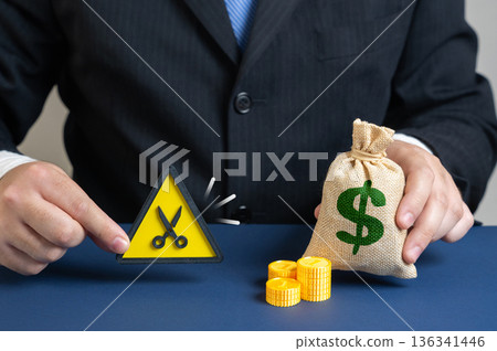 A businessman or official cuts the budget. Reduce costs and save money. Financial optimization concept about crisis response. Smart spending control and corporate efficiency strategy. A businessman or official cuts the budget. Reduce costs and save money. Financial optimization concept about crisis response. Smart spending control and corporate efficiency strategy. 136341446