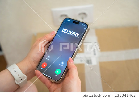 A girl receives a call from a delivery person. Parcel delivery and dispatch via courier. Modern logistics story about online shopping, fast shipping, and convenient home delivery service 136341462
