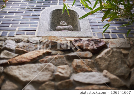 Buddha statue in wall niche with stone and brick texture 136341607