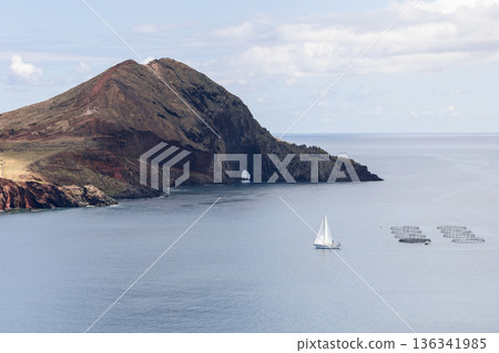 Sailboat near aquaculture cages off Point of Saint Lawrence Madeira, calm bay 136341985
