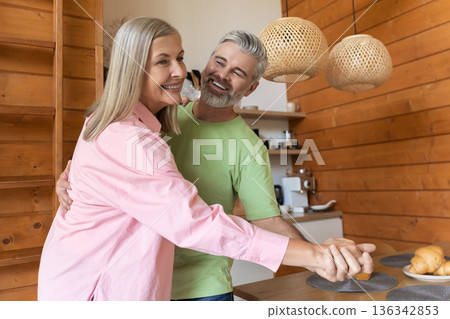 Older adults moving playfully in kitchen setting Older adults moving playfully in kitchen setting 136342853