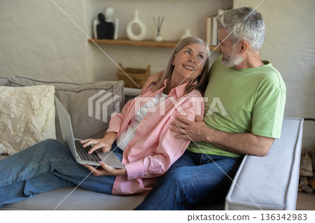 Couple enjoying online content on portable computer 136342983