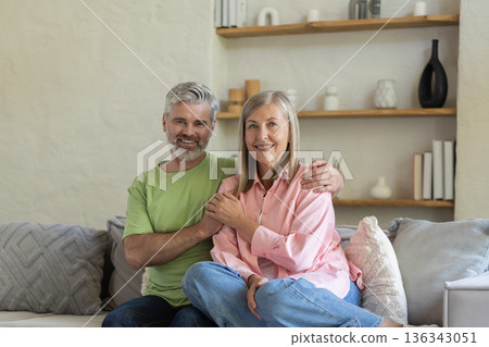 Mature people embracing and sitting on sofa enjoying moment of love Mature people embracing and sitting on sofa enjoying moment of love 136343051
