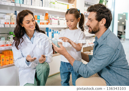Pharmacist advising parent and child on product selection Pharmacist advising parent and child on product selection 136343103