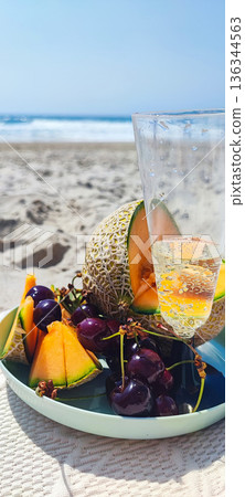 Picnic on the beach at sunset in boho style. Romantic dinner, friends party, summertime, food and drink conception Picnic on the beach at sunset in boho style. Romantic dinner, friends party, summertime, food and drink conception 136344563