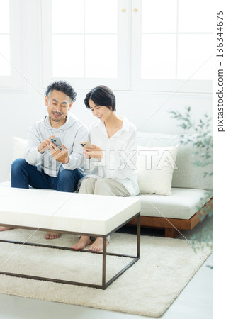 Middle-aged couple drinking coffee in the living room Middle-aged couple drinking coffee in the living room 136344675
