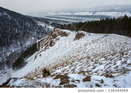 Panoramic view of snow covered mountains with pine tree forest in winter. Cold weather landscape photography for nature and travel concept. Panoramic view of snow covered mountains with pine tree forest in winter. Cold weather landscape photography for nature and travel concept. 136344949