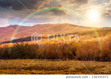 early spring rural landscape in carpathian mountains at sunset. beautiful view of countryside scenery with field in march in evening light. hope, expectation, new beginning and bright future 136345071