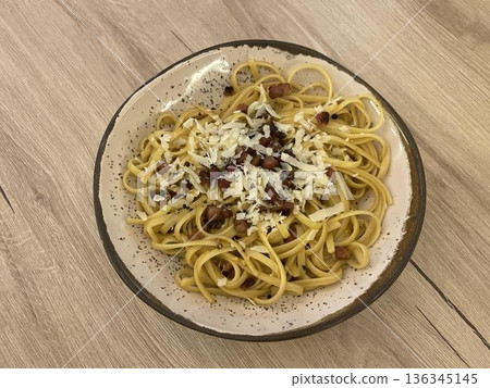 a plate of pasta with cheese and bacon 136345145