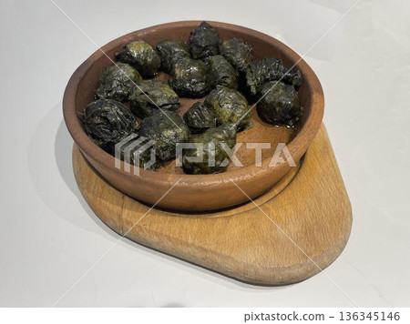 a bowl of dolma on a wooden board a bowl of dolma on a wooden board 136345146