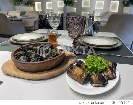 a bowl of dolma and badrijani's plate on a table a bowl of dolma and badrijani's plate on a table 136345195