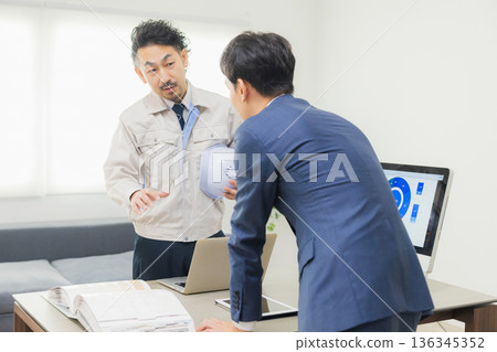 工程師們在辦公室一邊開會一邊查看文件。 工程師們在辦公室一邊開會一邊查看文件。 136345352