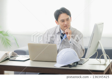 Engineer looking at smartphone in office 136345425