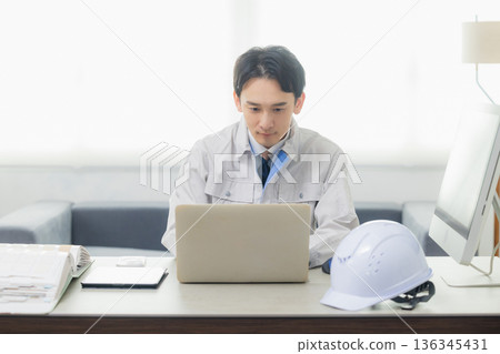 工程師在辦公室看著智慧型手機 136345431