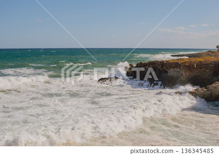 Furious storm and white foam turquoise waves crashing on rocky coast. Furious storm and white foam turquoise waves crashing on rocky coast. 136345485