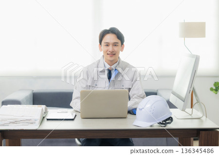 Engineer looking at smartphone in office 136345486