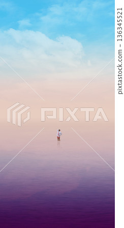 Dreamlike composition lone man standing in endless pastel horizon. 136345521
