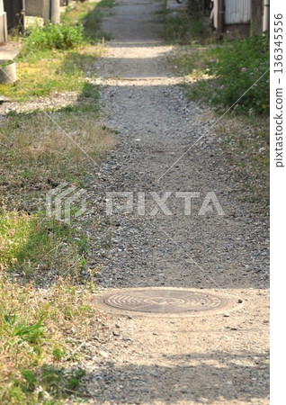 A manhole in a back alley A manhole in a back alley 136345556