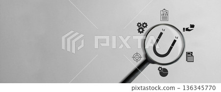Minimalist banner of a magnifying glass over a magnet icon, surrounded by business symbols representing inbound marketing, customer attraction, and strategic growth on gray background 136345770