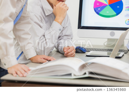 Engineers having a meeting while looking at documents at the office 136345980