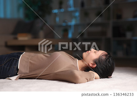 Asian woman relaxing lying on a carpet in the night Asian woman relaxing lying on a carpet in the night 136346233