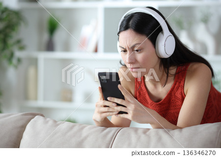 Suspicious asian woman watching media on phone 136346270