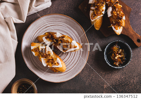 Snack sandwiches with brie cheese and caramelized onions on a plate on the table top view 136347512