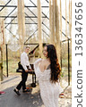 Romantic couple enjoying outdoor wedding music in bohemian gazebo 136347656