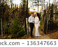 Loving expecting couple standing near rustic wooden fence 136347663