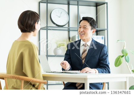 一位商人向一位中年婦女推銷商品。 一位商人向一位中年婦女推銷商品。 136347681