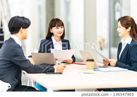 People reviewing documents at a meeting 136347903