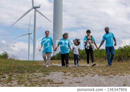 Family with daughter walking on field on wind farm. Family with daughter walking on field on wind farm. 136347908