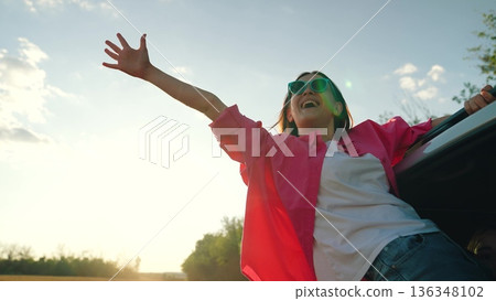 Happy girl waving from car, happy female face, summer trip sea, vacation picnic party, vacation fun, people sunglasses, free spirit lifestyle, emotional travel freedom, woman with enthusiasm, enjoying 136348102