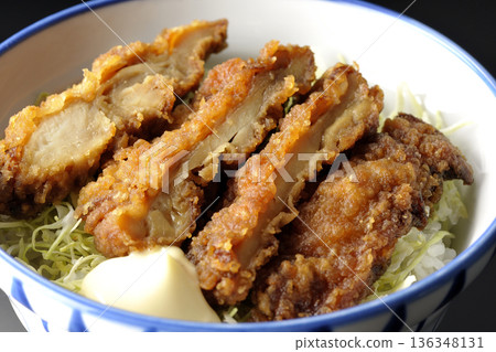 Mayonnaise and fried chicken rice bowl photographed against a black background 136348131