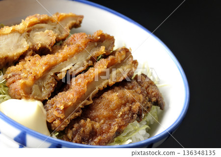 Mayonnaise and fried chicken rice bowl photographed against a black background 136348135