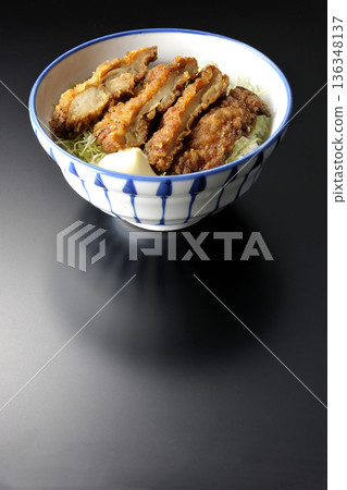 Mayonnaise and fried chicken rice bowl photographed against a black background 136348137