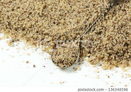 Crushed walnut kernels in spoon close-up on white background. Crushed walnut kernels in spoon close-up on white background. 136348596