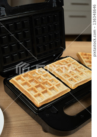 Freshly Baked Golden Waffles Inside an Open Electric Waffle Maker. 136348646