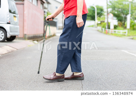 一位拄著拐杖在戶外行走的老婦人，沒有臉部特徵，老人形象 136348974