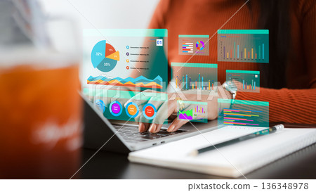 Asian businesswoman analyzing financial data with virtual dashboard on laptop. Concept of digital marketing, big data analytics, technology innovation and business intelligence. 136348978