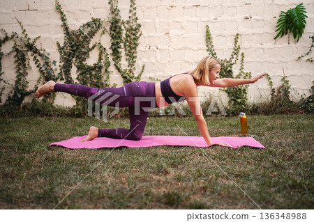 Mother embraces fitness with strength exercises in a serene garden setting 136348988
