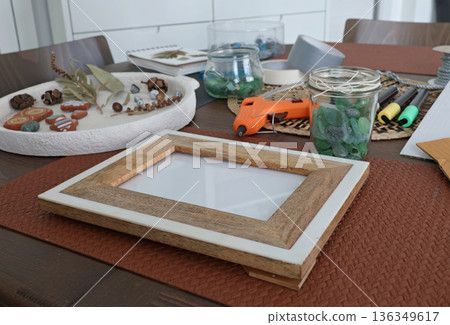 Sea glass in frame. Making art from natural materials. Glue gun and driftwood for picture. Hobbies and creativity. Reuse and nature, ecology.  136349617