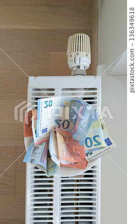 Euro notes on radiator portray hardship across Baltic region, hardship squeezes wages, hardship pushes families to ration warmth, inequality, crisis news, support programs 136349618