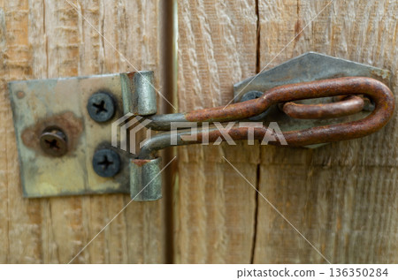 Antiquated metallic clasp affixed to rustic wooden frame Antiquated metallic clasp affixed to rustic wooden frame 136350284