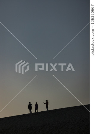 Silhouettes of people riding horseback and the sunset sky at Tottori Sand Dunes in Fukube Town, Tottori City, Tottori Prefecture, Japan Silhouettes of people riding horseback and the sunset sky at Tottori Sand Dunes in Fukube Town, Tottori City, Tottori Prefecture, Japan 136350667