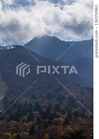 The autumn leaves of Mt. Daisen illuminated by the sun as seen from Mount Goen Noroshidai in Daisen Town, Saihaku District, Tottori Prefecture, Japan 136350961